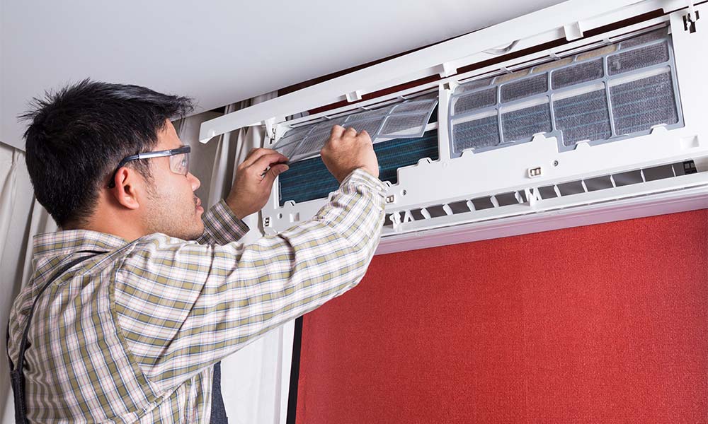 tech maintaining a ductless air conditioner